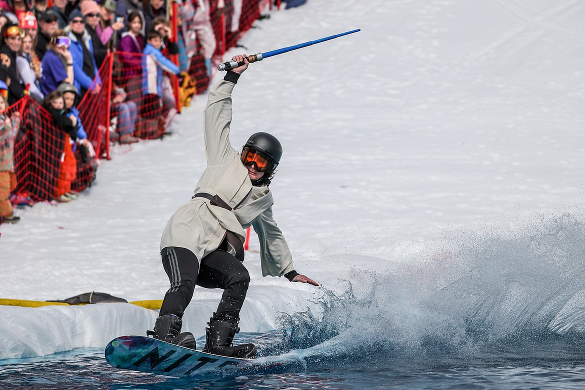 A competitor slices through the cold pool on a snowboard at the Pond Skim on Saturday. (JP Edge photo)