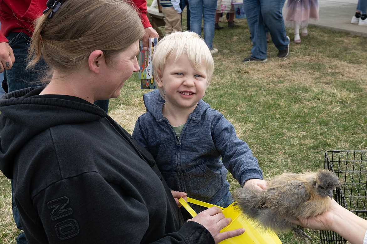 2 year old River Horton pets a chick at the Plains Easter egg hunt. (Tracy Scott/Valley Press)