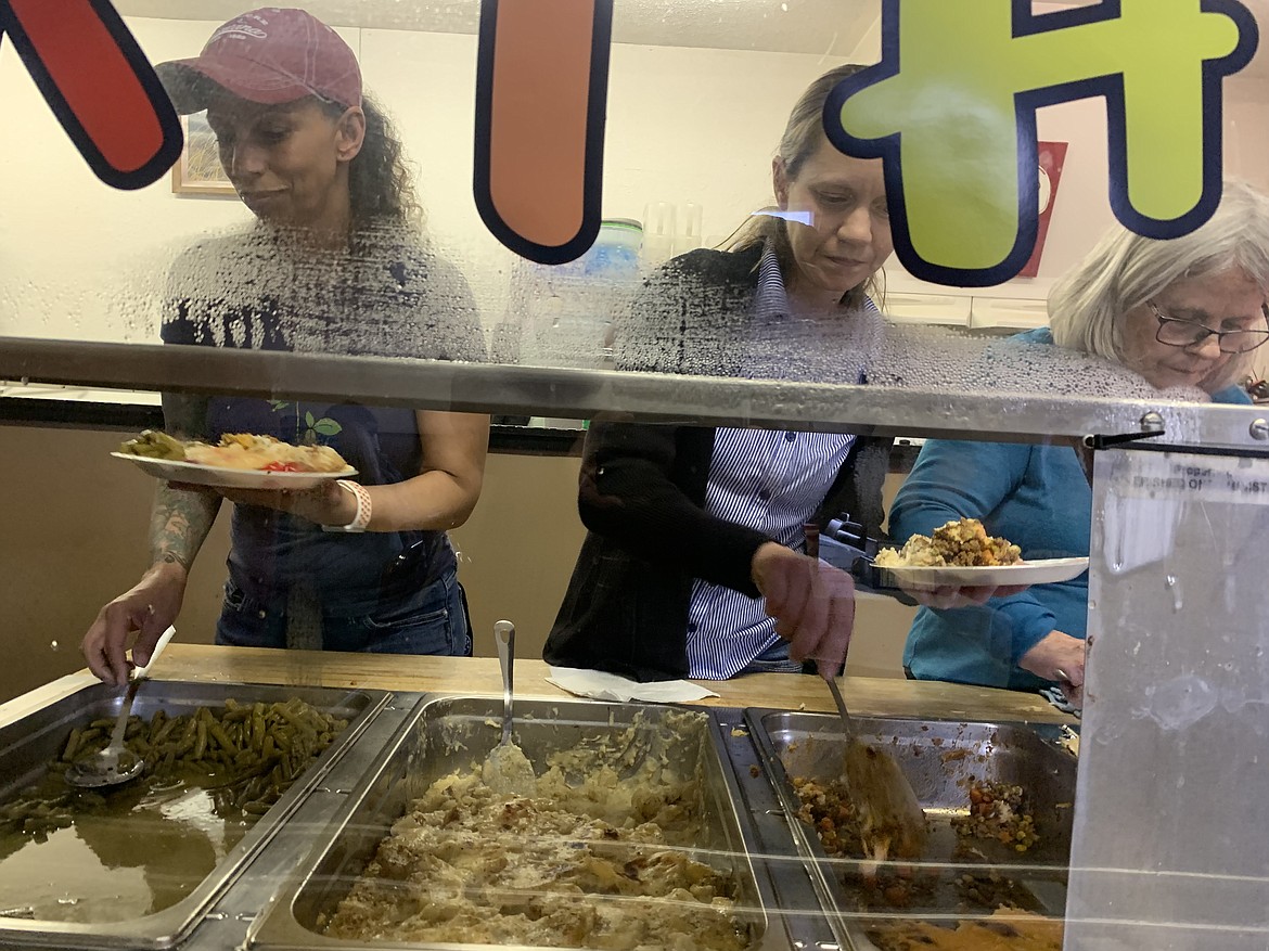 Volunteers, from left, Amy Ankley, Carla Leach and Ellen Taggart prepare meals during Saturday's last soup kitchen run by Cherished Ones Ministries.