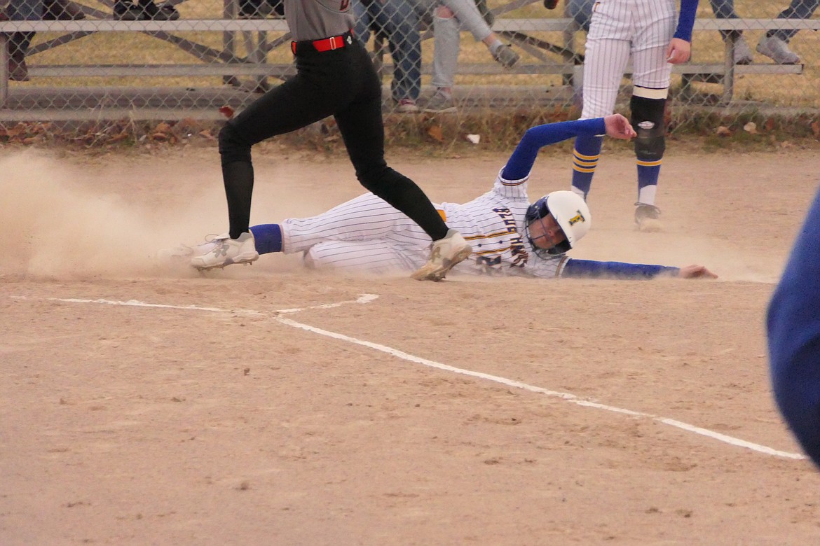 Teagan Sander, a Thompson Falls sophomore, slides safely across home plate with a run during the Lady Hawks game with Eureka this past Friday in T Falls.  (Chuck Bandel/VP-MI)