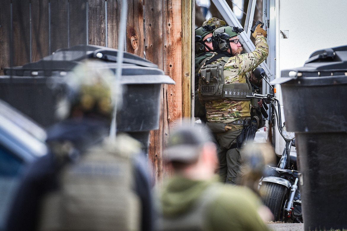 Law enforcement personnel prepare to enter an RV after a suspect involved in an armed standoff had been taken into custody between Second and Third Avenue West North in Kalispell on Tuesday, April 11. (Casey Kreider/Daily Inter Lake)