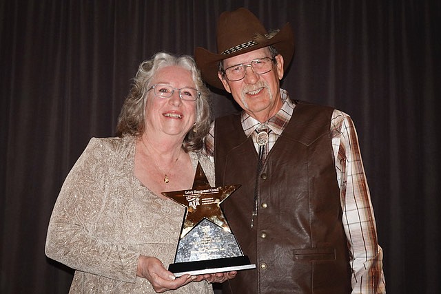 James and Rebecca Self pose with the national trucker of the year award presented at an award banquet to Jim by the American Trucking Association for driving over 6 million miles with no accidents.