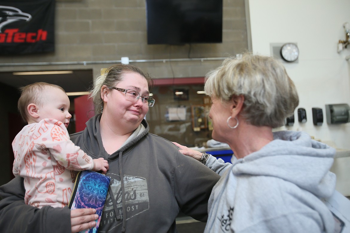 Charity Reimagined founder Maggie Lyons on Wednesday hugs Natausha Green and daughter Meadow after Green received the title to a 2002 Ford Escape through a new affordable car program launched by Charity Reimagined and KTEC.