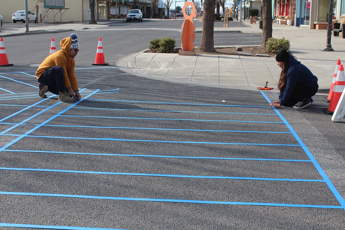 Draven Pointer and Marissa Lopez of the Better Block Foundation lay out the design grid Thursday morning at C Street in Quincy.