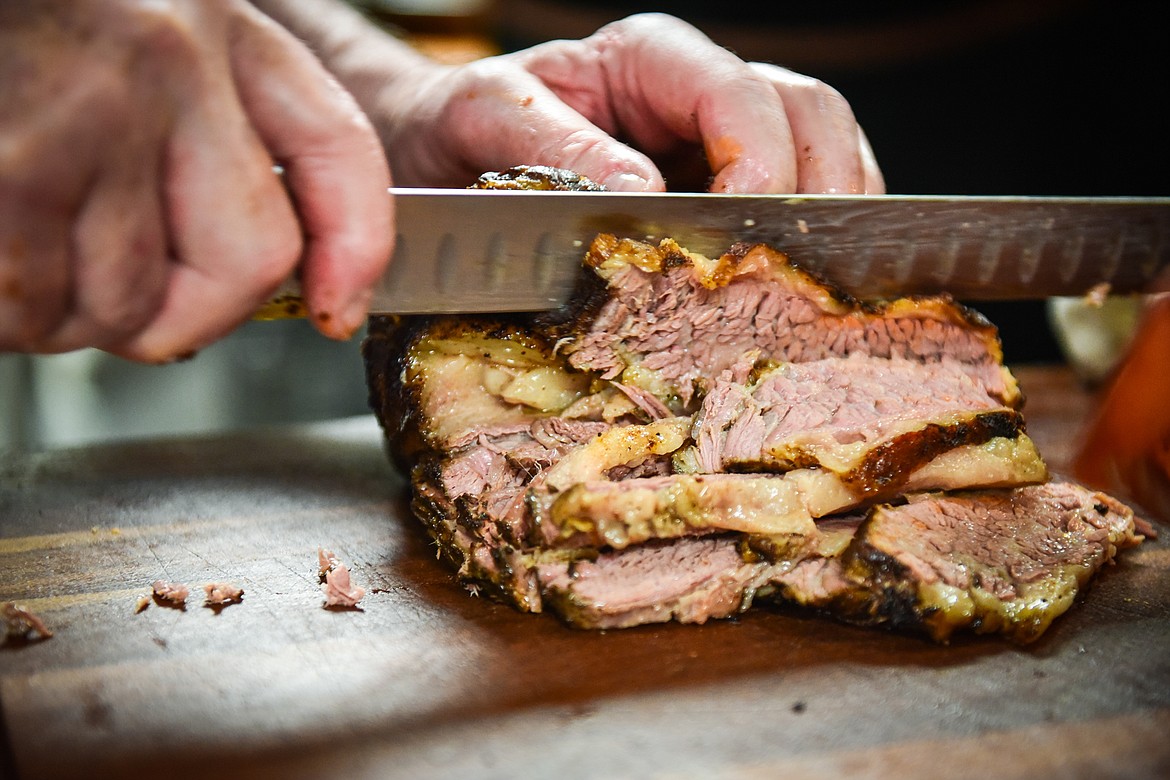 Chef Howard Karp slices brisket for an order at Flathead Valley Community College's pop-up lunch restaurant "Smolder," operated by students in the school's Culinary Institute of Montana on Thursday, April 13. (Casey Kreider/Daily Inter Lake)