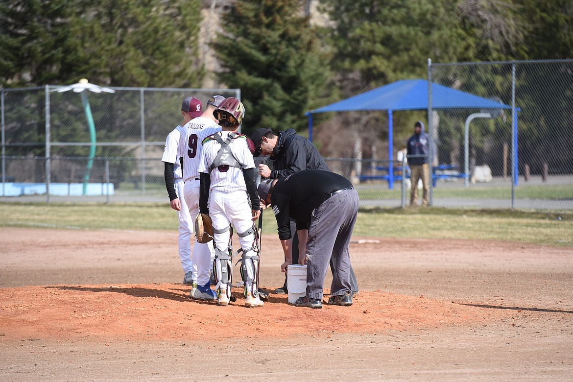 Troy baseball coaches work on the pitcher's mound against Mission on Thursday, April 13, 2023. (Scott Shindledecker/The Western News)