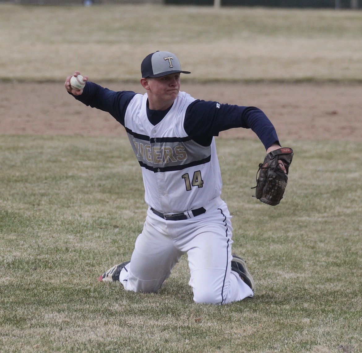 MARK NELKE/Press
Timberlake junior Grant Allaway (14) throws from his knees after fielding a ground ball against Bonners Ferry on Friday in Spirit Lake.