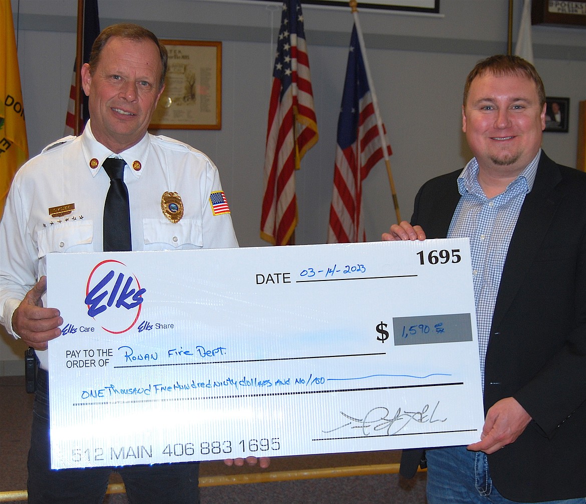 Ronan Police Chief Chris Adler receives donation from Mission Valley Elks President Justin Kalmbach.