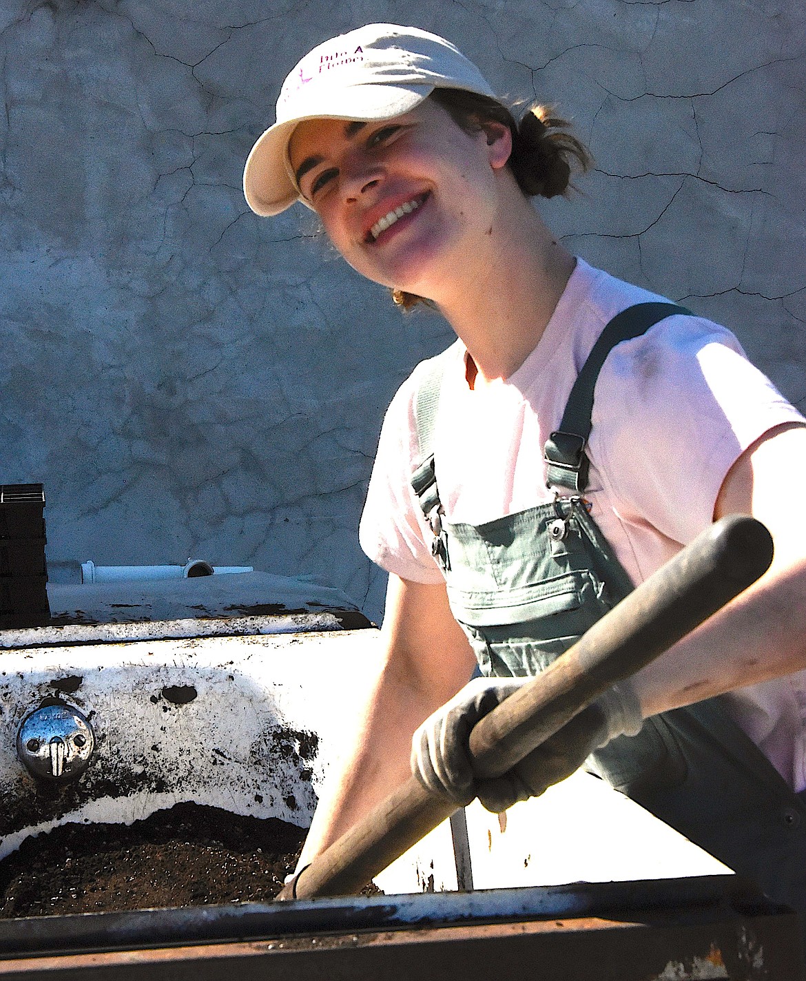 Flynn Hibbs, who works at Harlequin Organic Produce, mixes soil and water for the high tower greenhouses. (Berl Tiskus/Leader)