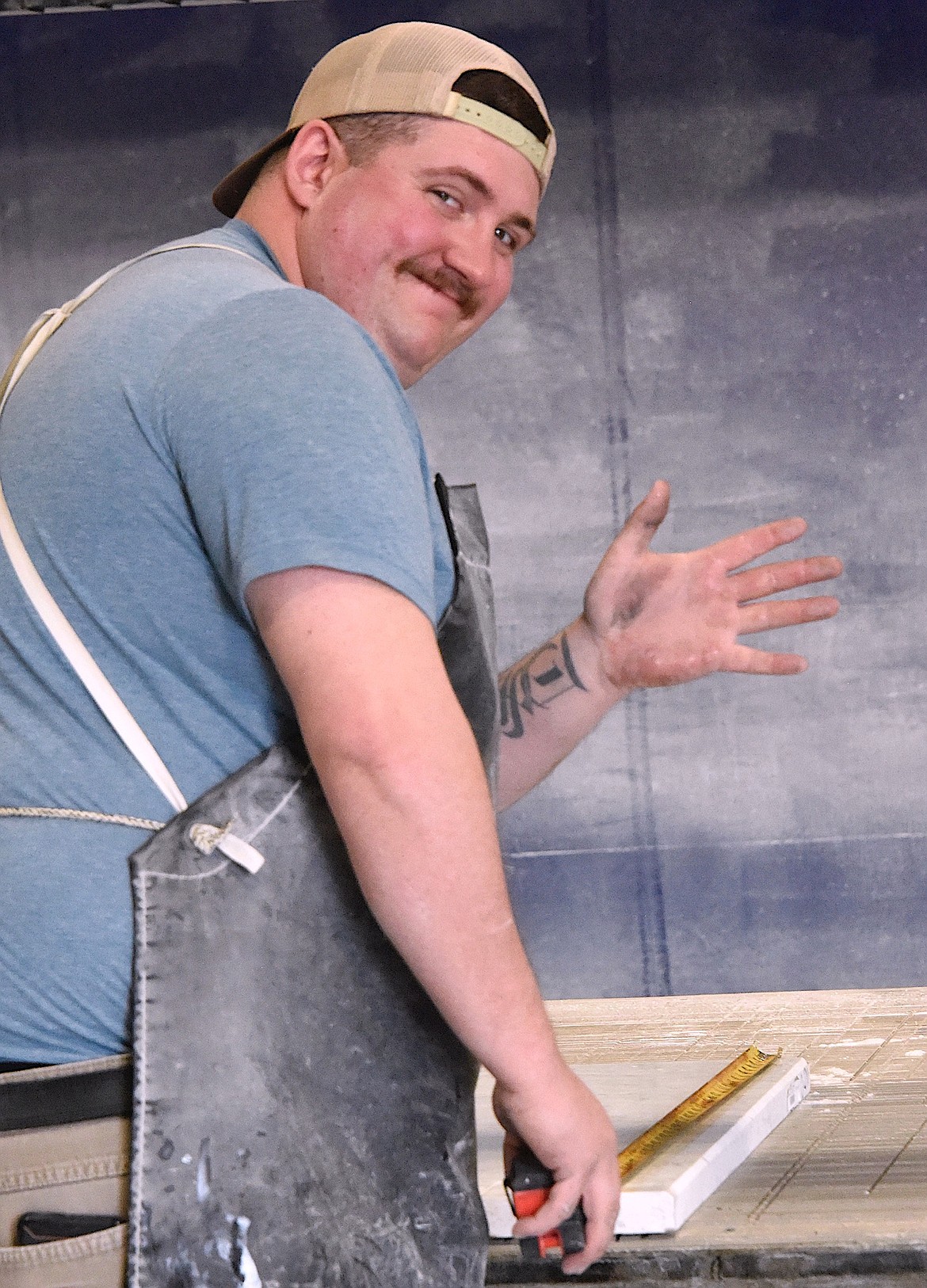 Timber Schauss, who works in the stone fabrication shop at Polson Stone and Tile, measures some stone. (Berl Tiskus/Leader)