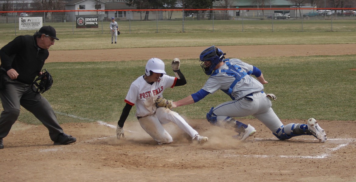 MARK NELKE/Press
Lucas Smith (2) of Post Falls slides home safely on a base hit in the second game, as Coeur d'Alene catcher Richard Hackett (12) applies the tag on Saturday at Post Falls High.