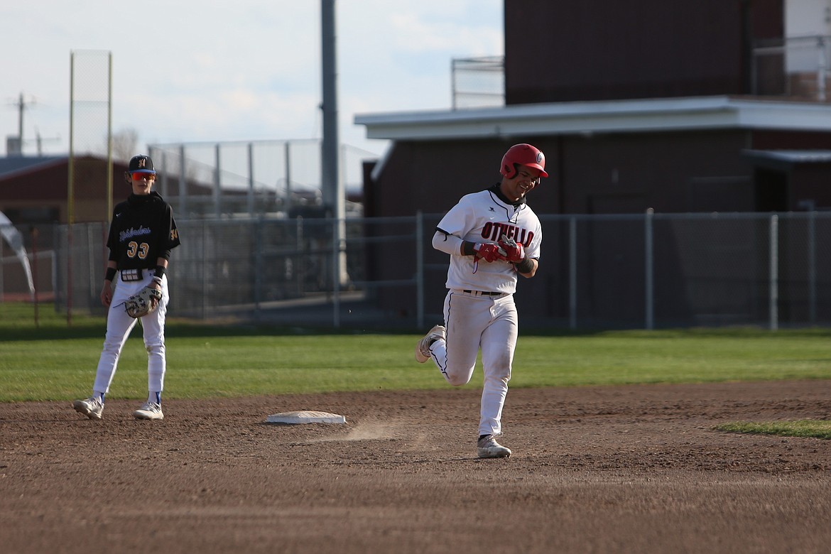 Othello sophomore Sonny Salazar, in white, smiles while trotting around the bases after hitting a solo home run against Hazen.