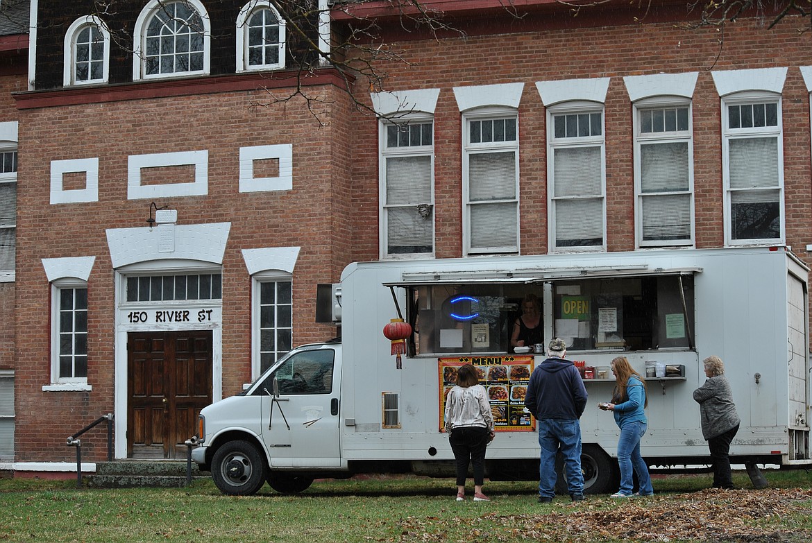 Even on a dreary wet spring day, the Golden Chopstick can draw a crowd on Tuesdays in Superior. Residents look forward to that day each week when the white food truck rolls into town, co-workers gather a list of orders to bring back to offices and businesses. And friends and neighbor's are offered the chance to mingle and catch up while waiting for their food. (Amy Quinlivan/Mineral Independent)