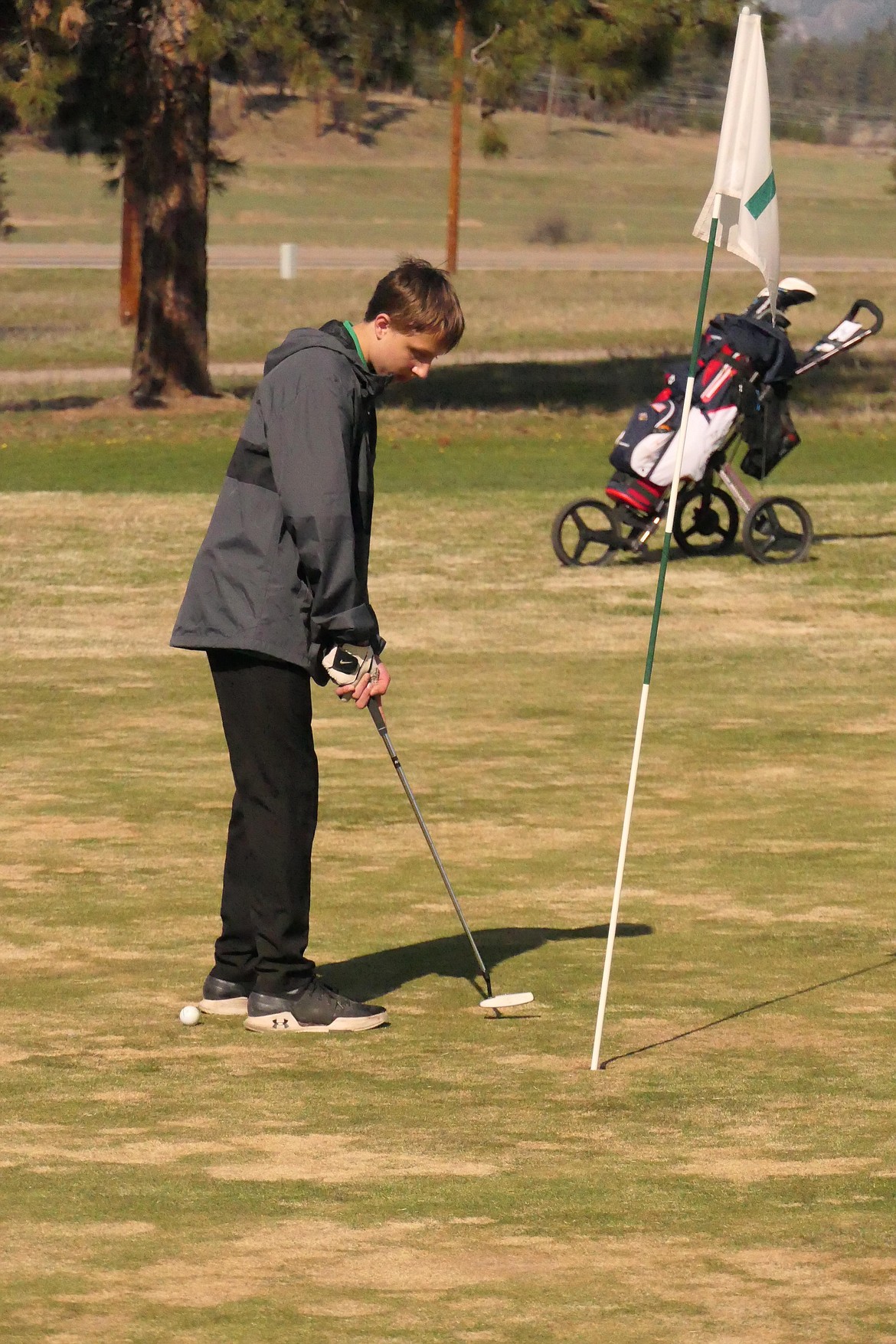 St. Regis golfer Kelton Simkins watches a short put find the cup during Friday's Plains Invitational golf tourney at Wild Horse Plains Golf Course northwest of Plains. (Chuck Bandel/VP-MI)