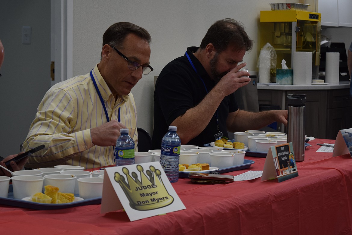 Moses Lake School Superintendent Monty Sabin and Grant County International Airport Director Rich Mueller carefully judge some of the 10 chilis entered in Greenpoint Technologies’ annual chili competition on Monday.