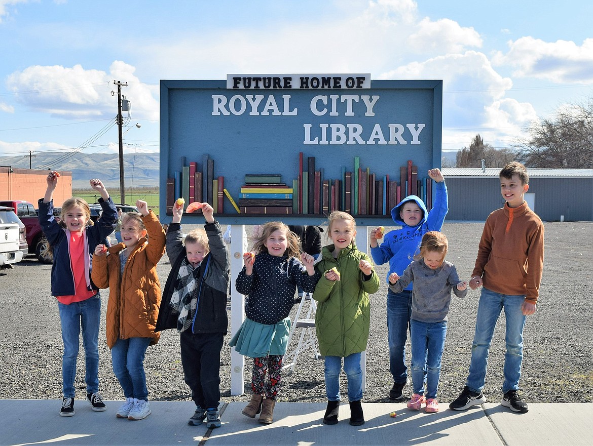 Future library patrons cheer as the sign marking the location of the planned Royal City Library was unveiled April 11. The new library, when complete, will be more than three times as large as the existing facility, which stands across the street from the new site.