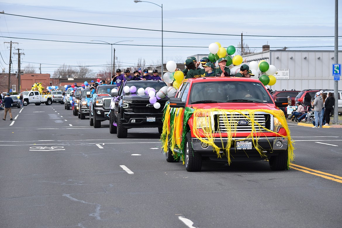 Decorated pickup trucks make their way down Fourth Avenue during the annual Dick Kelly Memorial Parade marking the formal start of the youth baseball and softball season Saturday morning in Moses Lake.