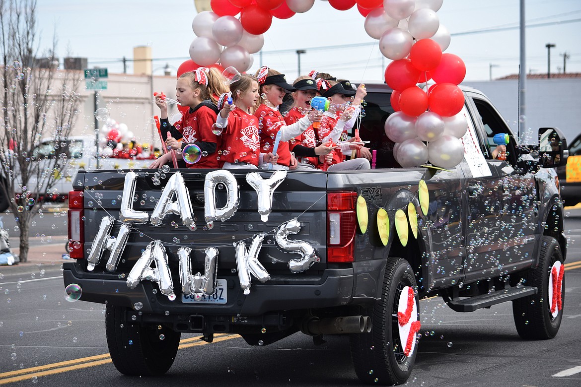 Players with the Lady Hawks girls softball team blow a long trail of bubbles as they make their way down Fourth Avenue during the annual Dick Kelly Memorial Parade on Saturday, the formal start of the city’s youth baseball and softball seasons.