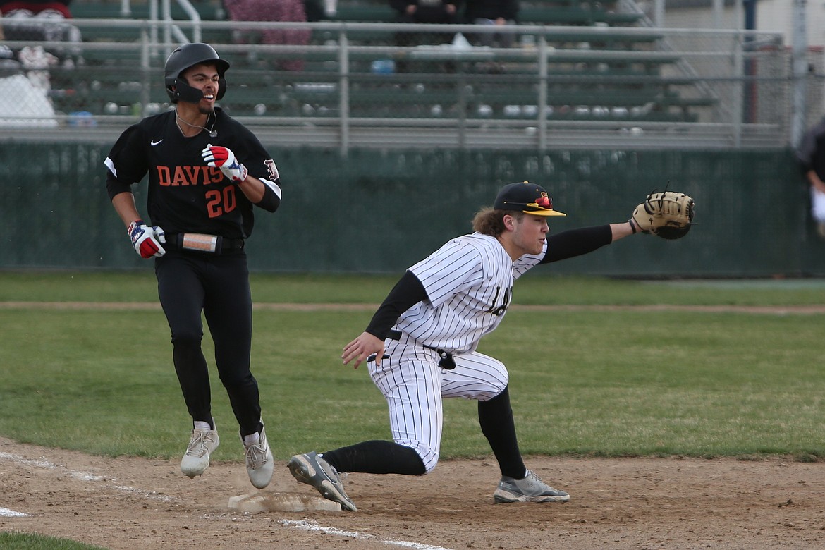 Moses Lake senior Josh West, right, catches a ball from a teammate for a groundout against Davis on Friday.