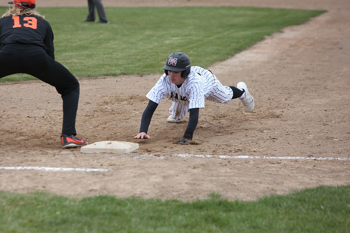 Moses Lake sophomore Adrian Martinez survives a pick-off attempt by diving back to first base during the first game of Friday’s doubleheader against Davis.