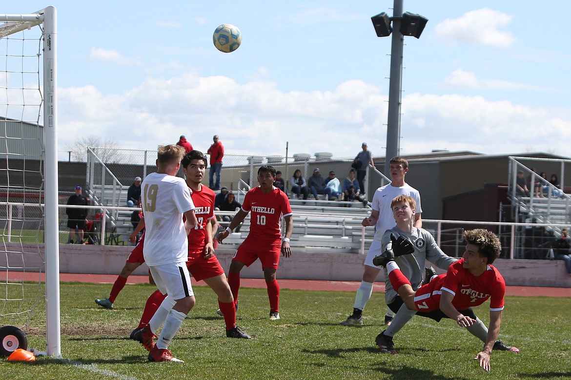 Othello junior Anthony Abundiz (7) looks back after heading the ball in front of the Selah net. Sophomore Jose Cabrera (10) later scored on a header.