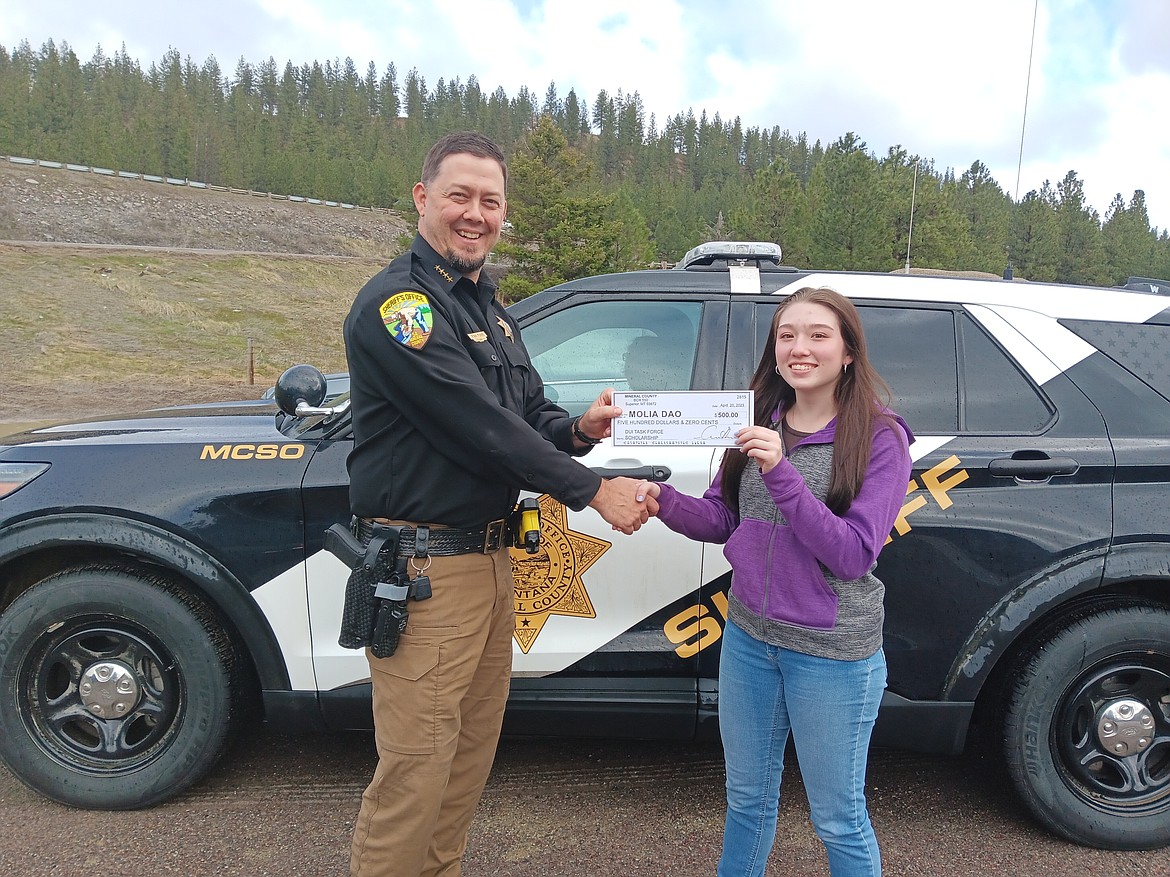 Sheriff Funke presents Molia Dao a check for $500 as the winner from Alberton High School of this year's Mineral County DUI Task Force scholarship.