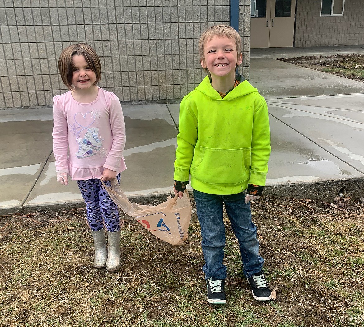 A pair of Farmin Stidwell students get their picture taken as they pick up litter around the school.