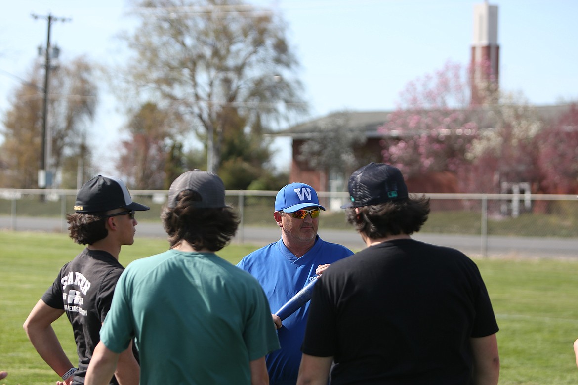 Warden Head Coach Travis Visker, in blue, talks with Cougar players ahead of a practice on Tuesday.