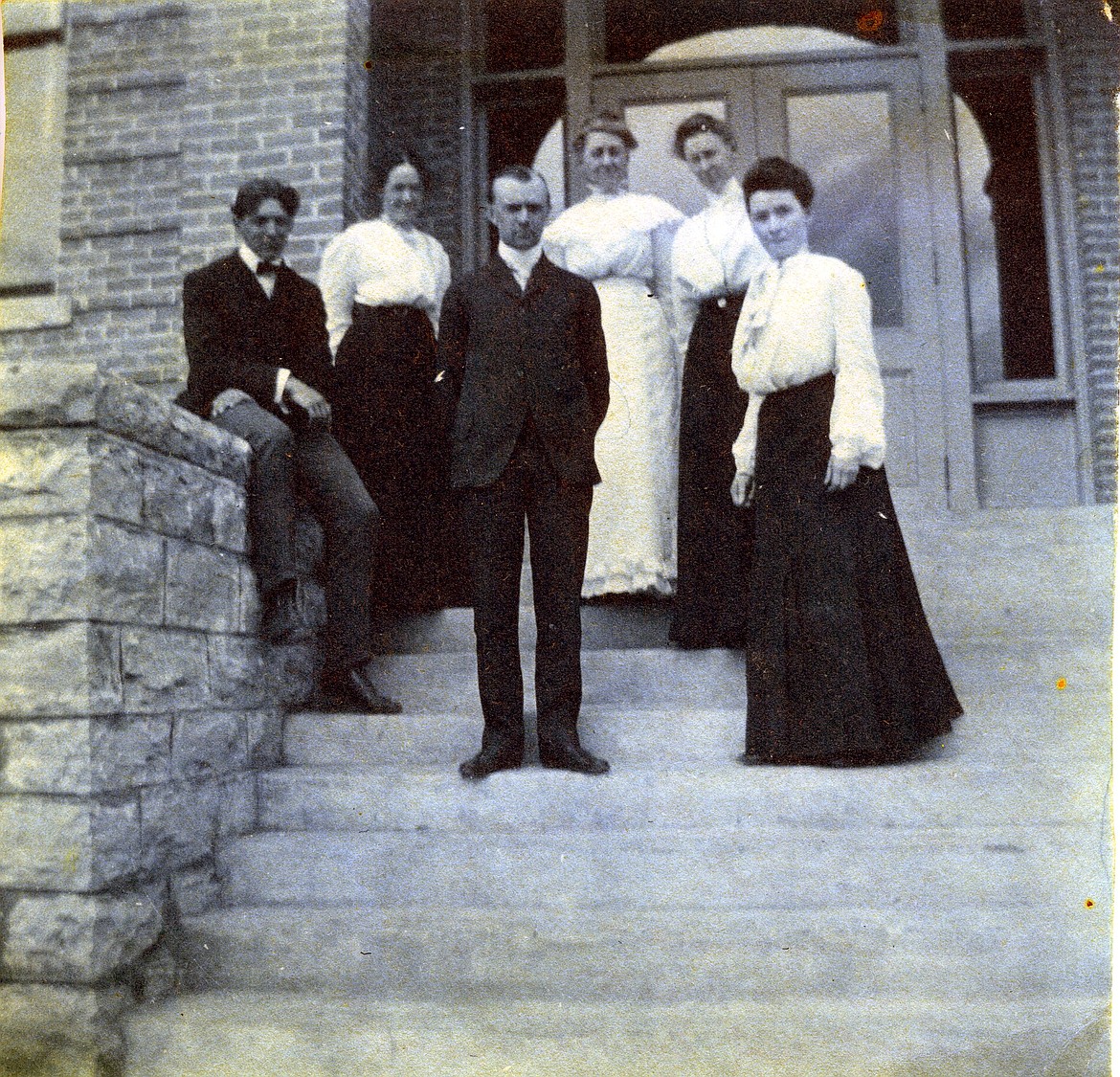 On the steps of Flathead High School, Bess Elliot Busey, Mabel Rich, May Trumper, Alice Butler White, Mr. Fault and Mr. Ketchum are photographed in 1908. (courtesy of the Northwest Montana History Museum)