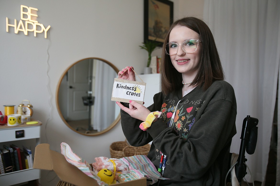 Kindness Crates founder Adrienne Roads, 20, shows off her logo while working on packing crates Tuesday in her Hayden home. The Kindness Crates motto is, "Small acts of kindness make big differences!"