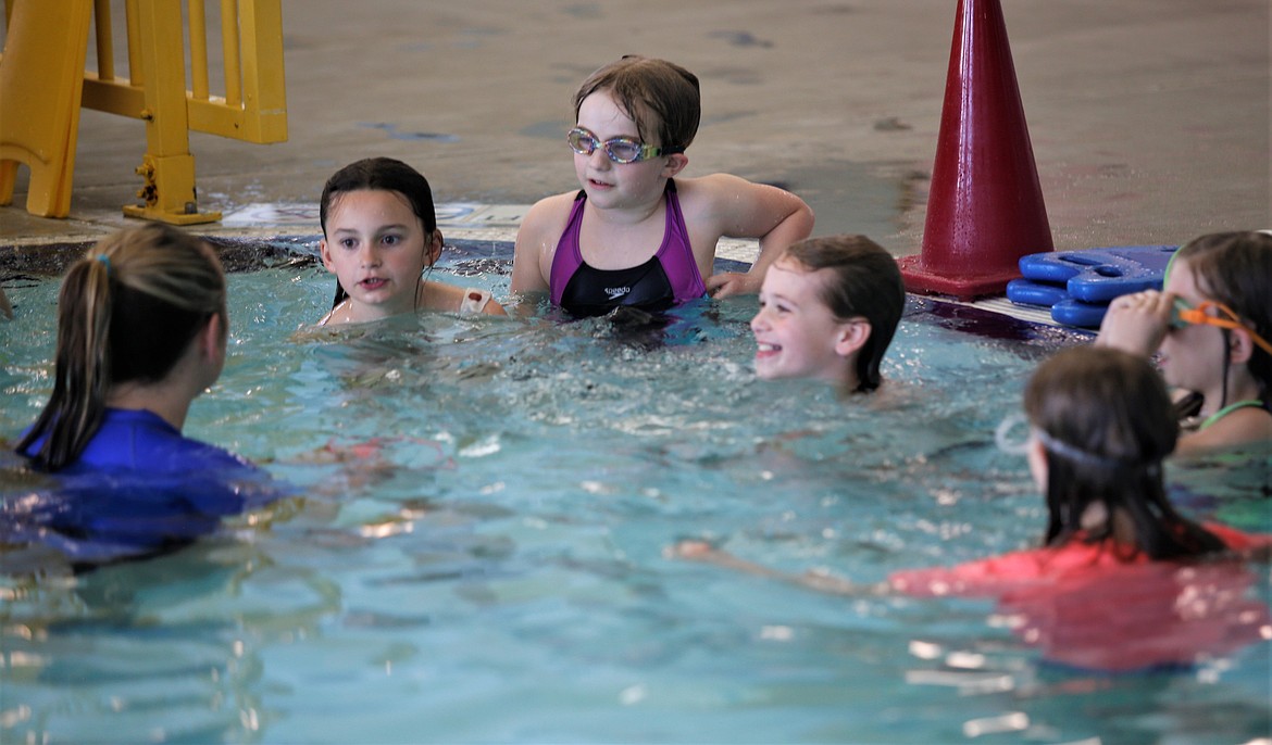 Volunteer Raygen Dutton speaks to youth in the Third Grade Swim program at the Kroc Center on Wednesday.