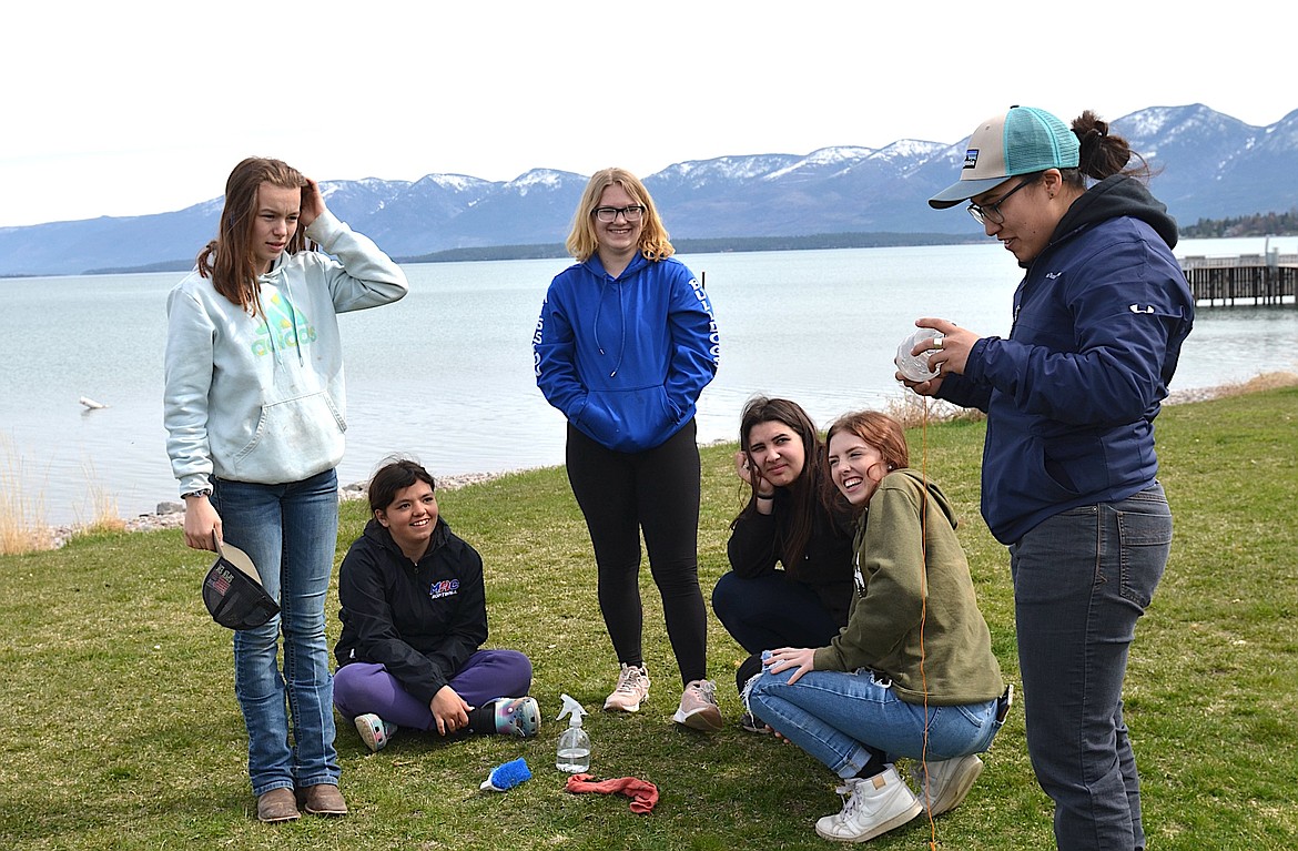 Katie Finley-Squeque of the CSKT Natural Resources Division checks the efforts of Mission High School students to "clean, drain and dry" plastic bottles during the recent Mussel Walk. (Kristi Niemeyer/Leader)