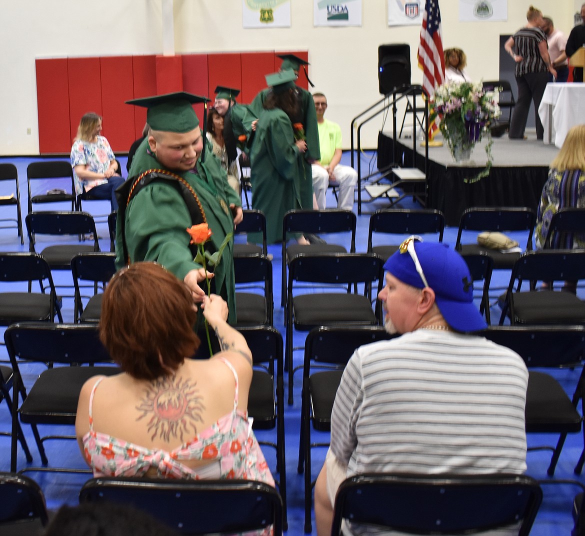 Graduating Job Corps student Micheal Baker hands a rose to his mother, Amy Gillette. Baker’s father Joe Foster, right, is a 1988 graduate of the center.