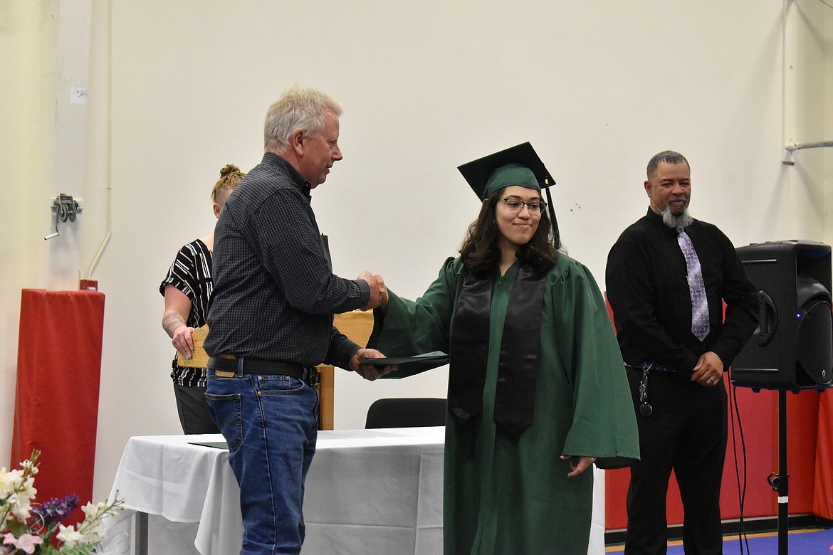 Illyana Reyes, right, receives her certificate from guest speaker Jim McKiernan at the Columbia Basin Job Corps Center graduation Thursday.