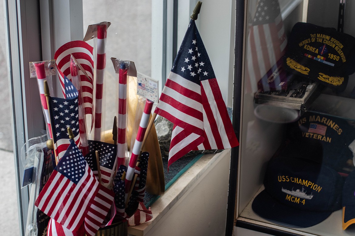 A display case and a bucket of American flags are seen at the entrance to the Northwest Montana Veterans Food Pantry in Evergreen on April 20, 2023. (Kate Heston/Daily Inter Lake)