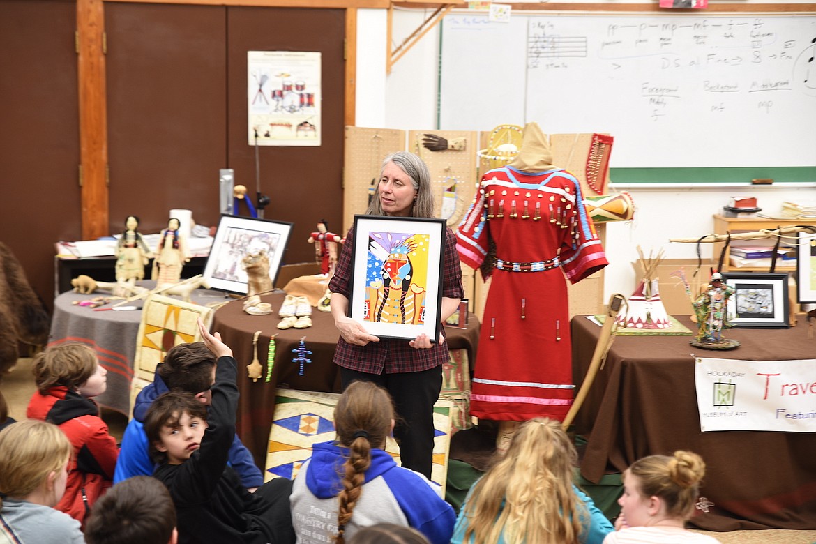 Hockaday Museum of Art Director of Education Kathy Martin shows Libby Elementary School students a Native painting at last Thursday's presentation. (Scott Shindledecker/The Western News)