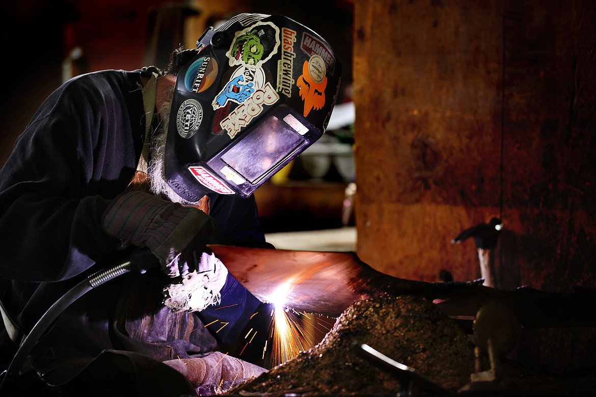 Jason Miller using a plasma cutter to do metal chasing work at the Kalispell Art Foundry in Evergreen. (Jeremy Weber/Daily Inter Lake)