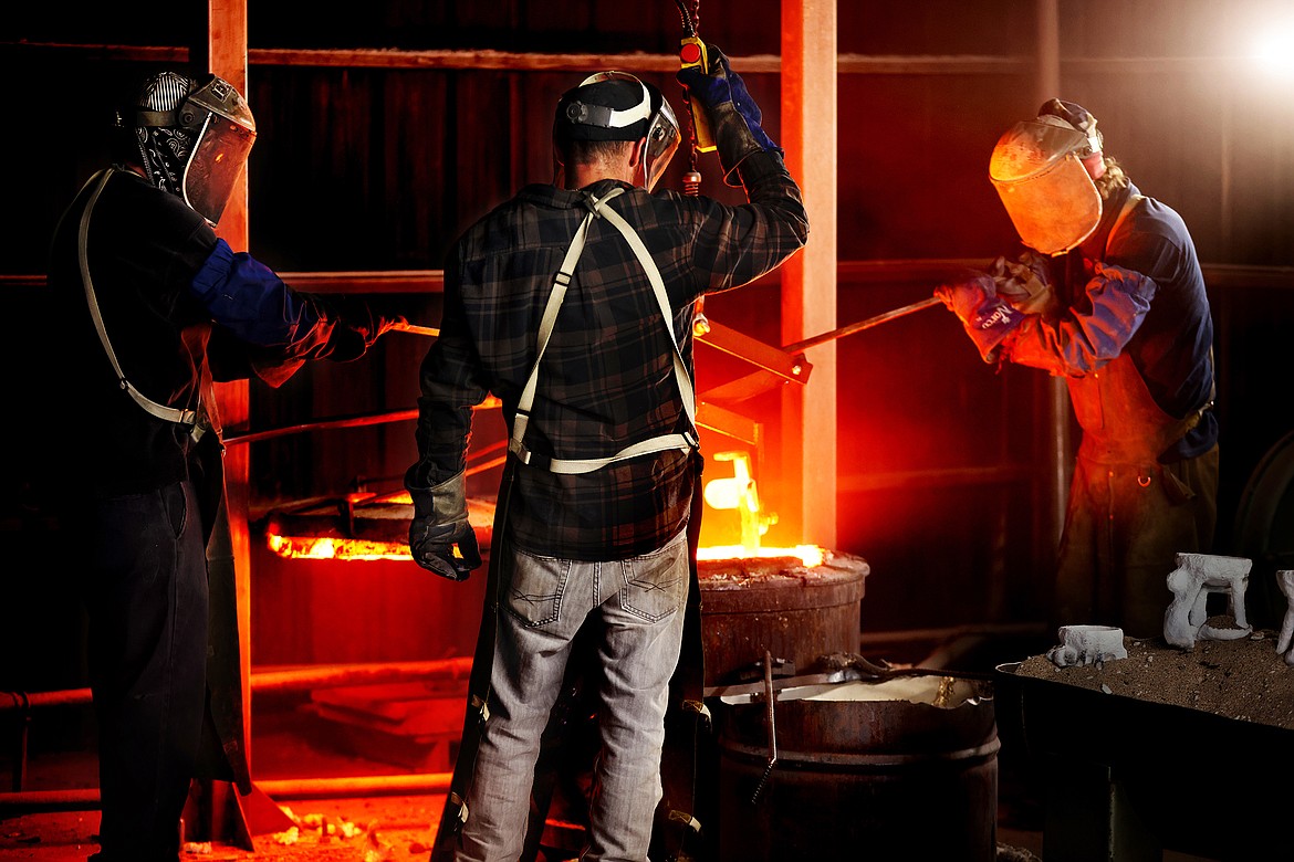 Jason Miller, Griffin Pierce and Harvey Fairchild prepare molten bronze for casting at the Kalispell Art Foundry in Evergreen. (Jeremy Weber/Daily Inter Lake)