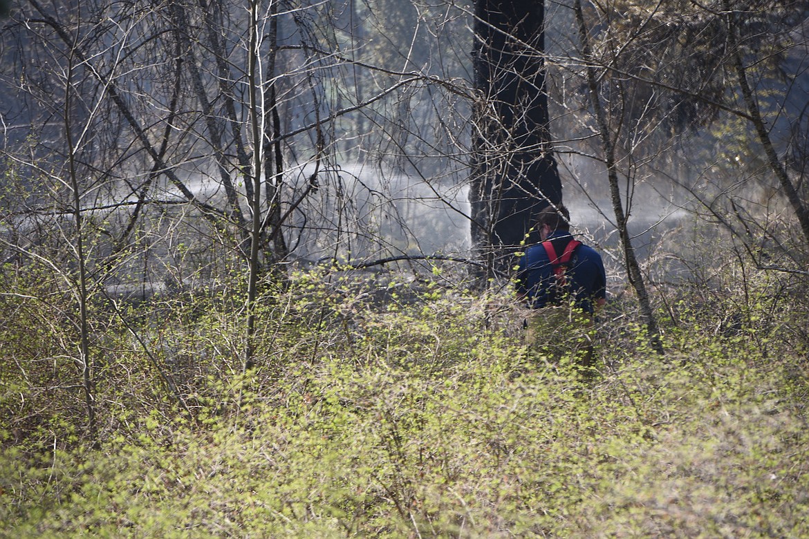 A Troy Rural Volunteer Fire Department firefighter battles a brush fire located just off Lake Creek Road Saturday afternoon. (Scott Shindledecker/The Western News)