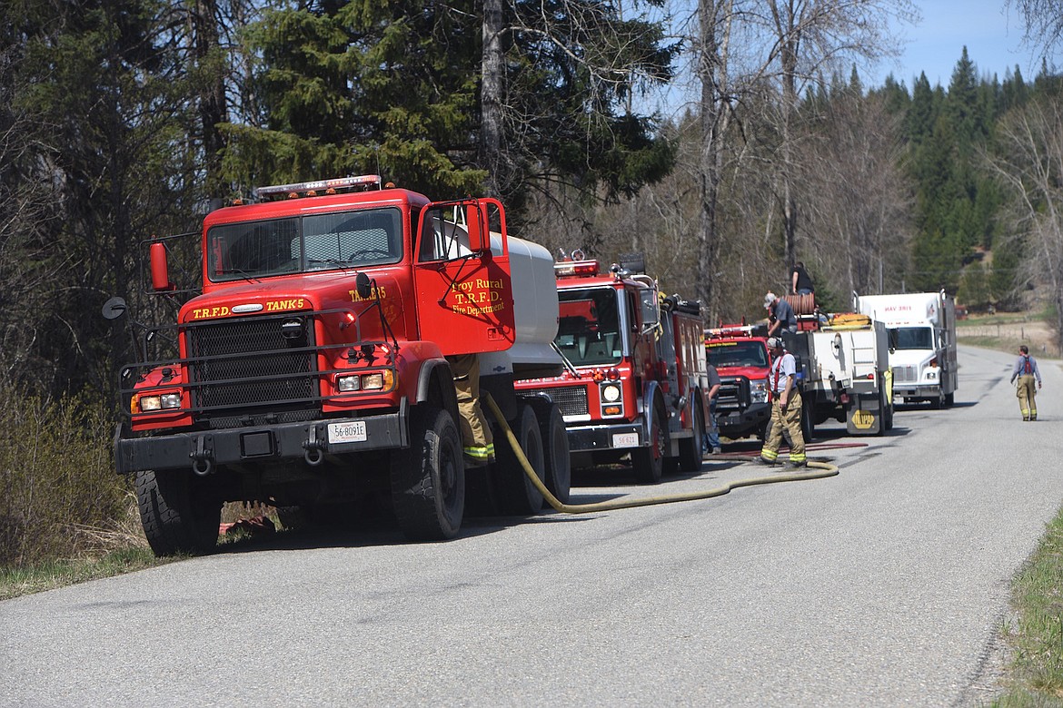 Troy Rural Volunteer Fire Department fire trucks line Lake Creek Road as firefighters battled a brush fire Saturday afternoon. (Scott Shindledecker/The Western News)