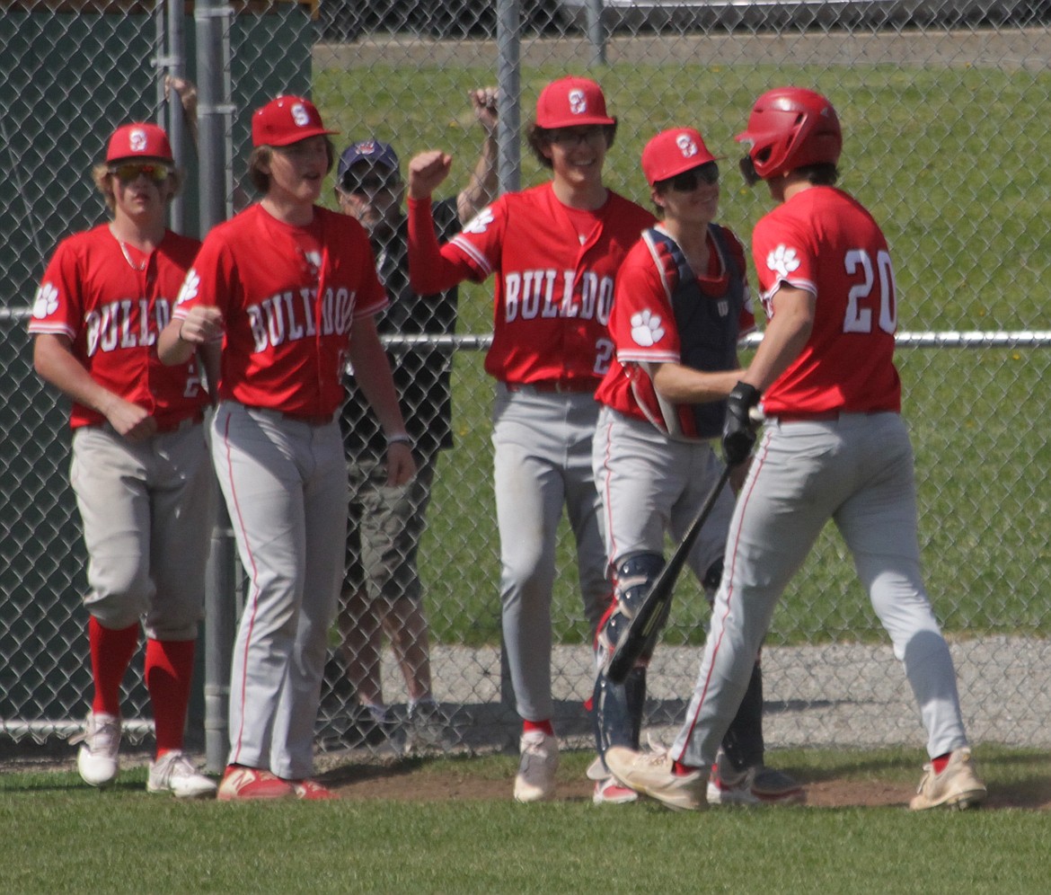 MARK NELKE/Press
Sandpoint sophomore Jesse Turner (20) is congratulated after scoring in the seventh inning of the first game of a doubleheader with Lakeland in Rathdrum. Turner's two-run double in the top of the seventh broke a 4-all tie as the Bulldogs won the first game 8-4.