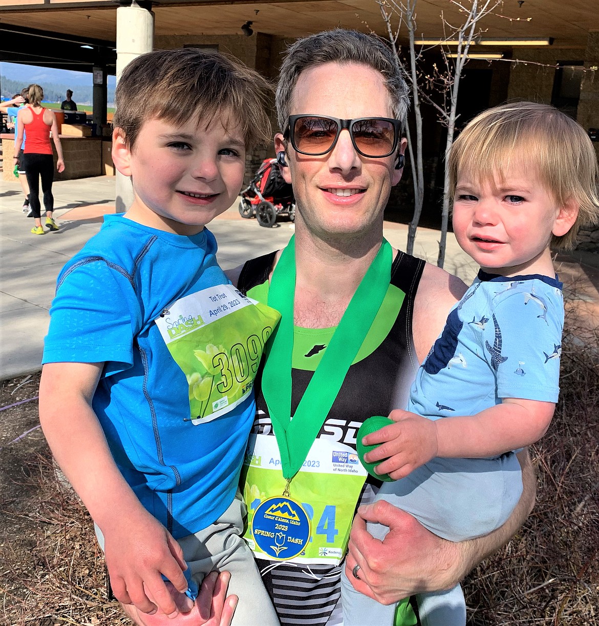 Colin Livingston, winner of the Spring Dash 10k, holds children Finn, left, and Graham after finishing at McEuen Park on Saturday.