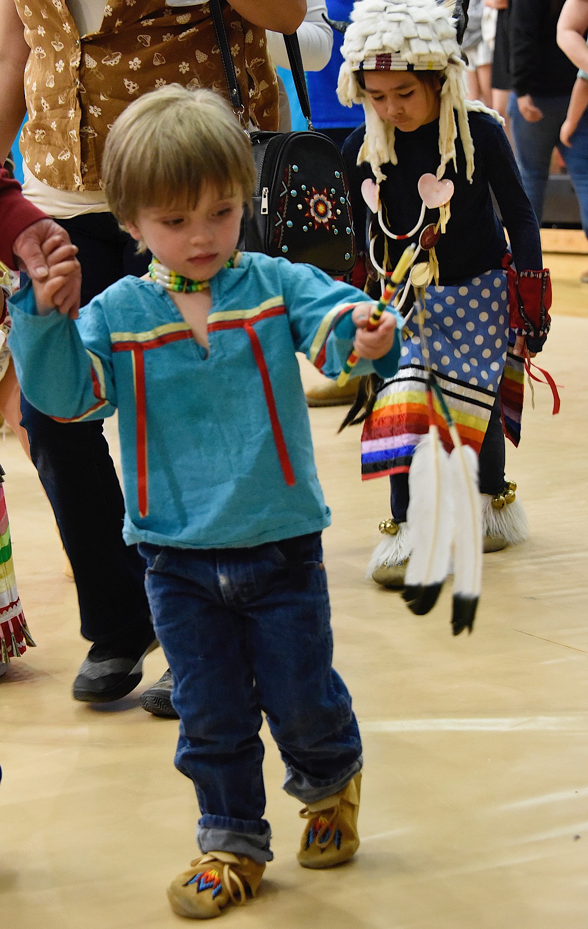 This pow-wow goer is interested in the feather he's holding.