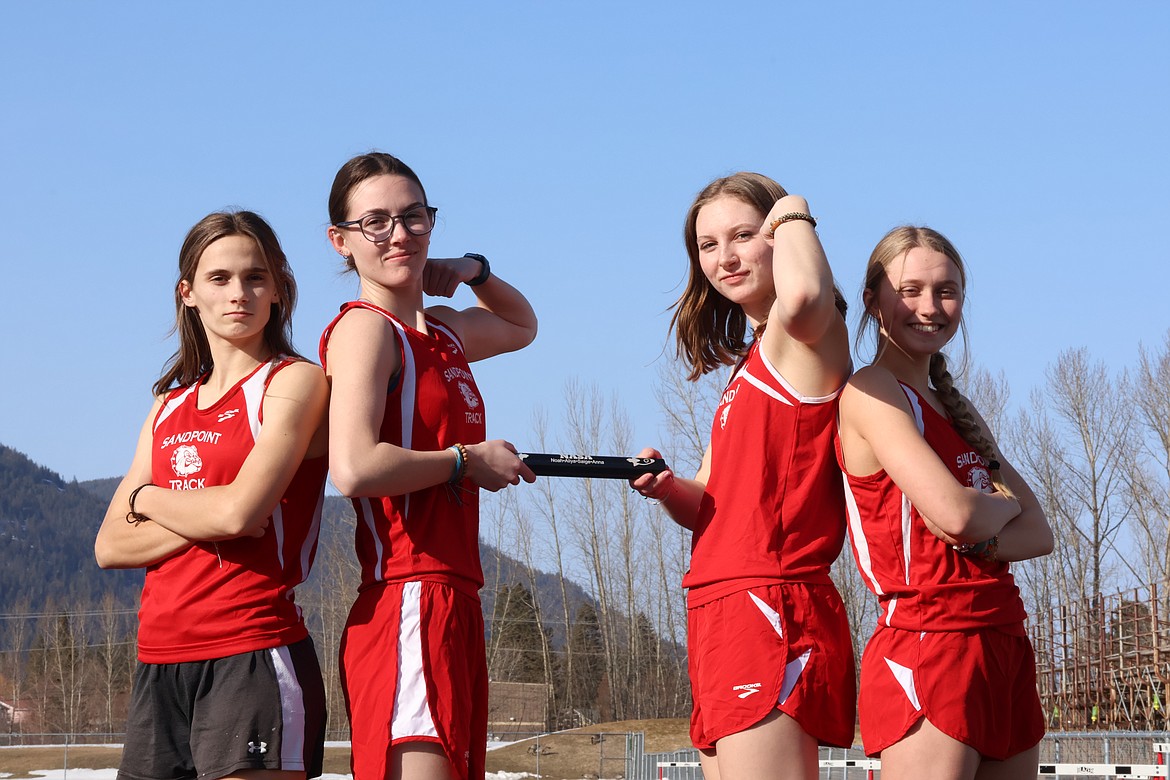 Left to right, Aliya Strock, Anna Reinink, Saige Smith, and Noah Roark pose with a relay baton at the Bonners Ferry Invitational earlier this season.