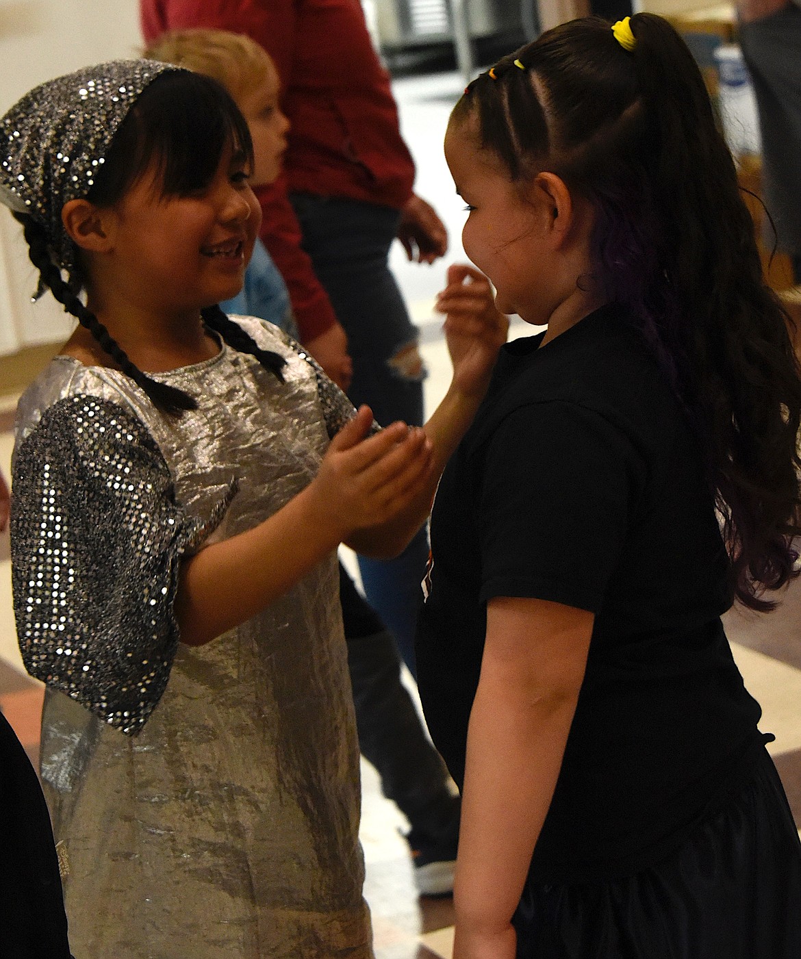 Averyana Beavers, 5, right, meets her friend Azelyn Swimmer, 8, at the pow-wow.