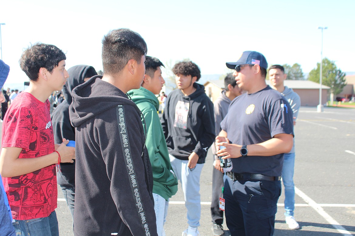 Grant County Fire District 8 firefighter Hermilo Tlatelpa, right, talks with Wahluke High School students about careers in the fire service.