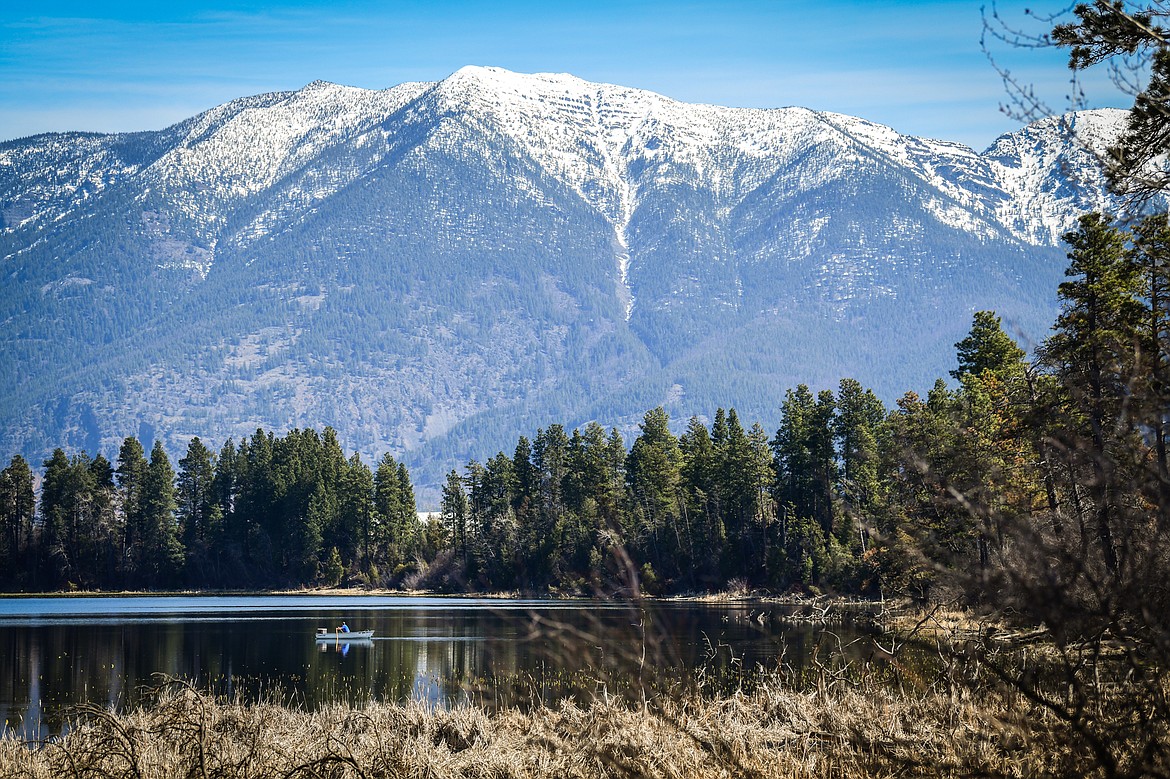 A fisherman paddles his boat out to a spot on McWenneger Slough on Friday, April 28. (Casey Kreider/Daily Inter Lake)