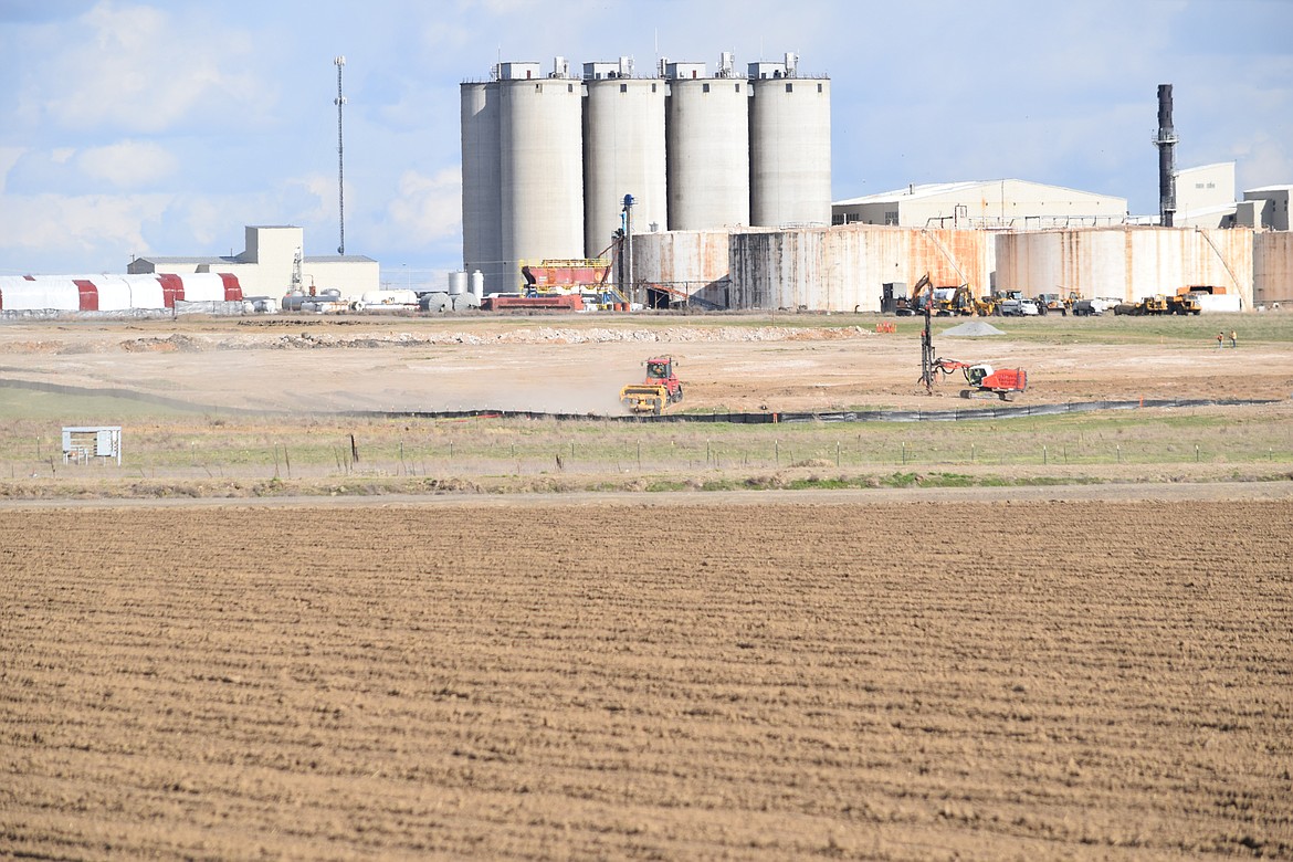 Construction crews grade and prepare the ground at Group14’s 44-acre site in Moses Lake, with the old U&I Sugar Refinery — the current Central Terminals business park — rising in the background.