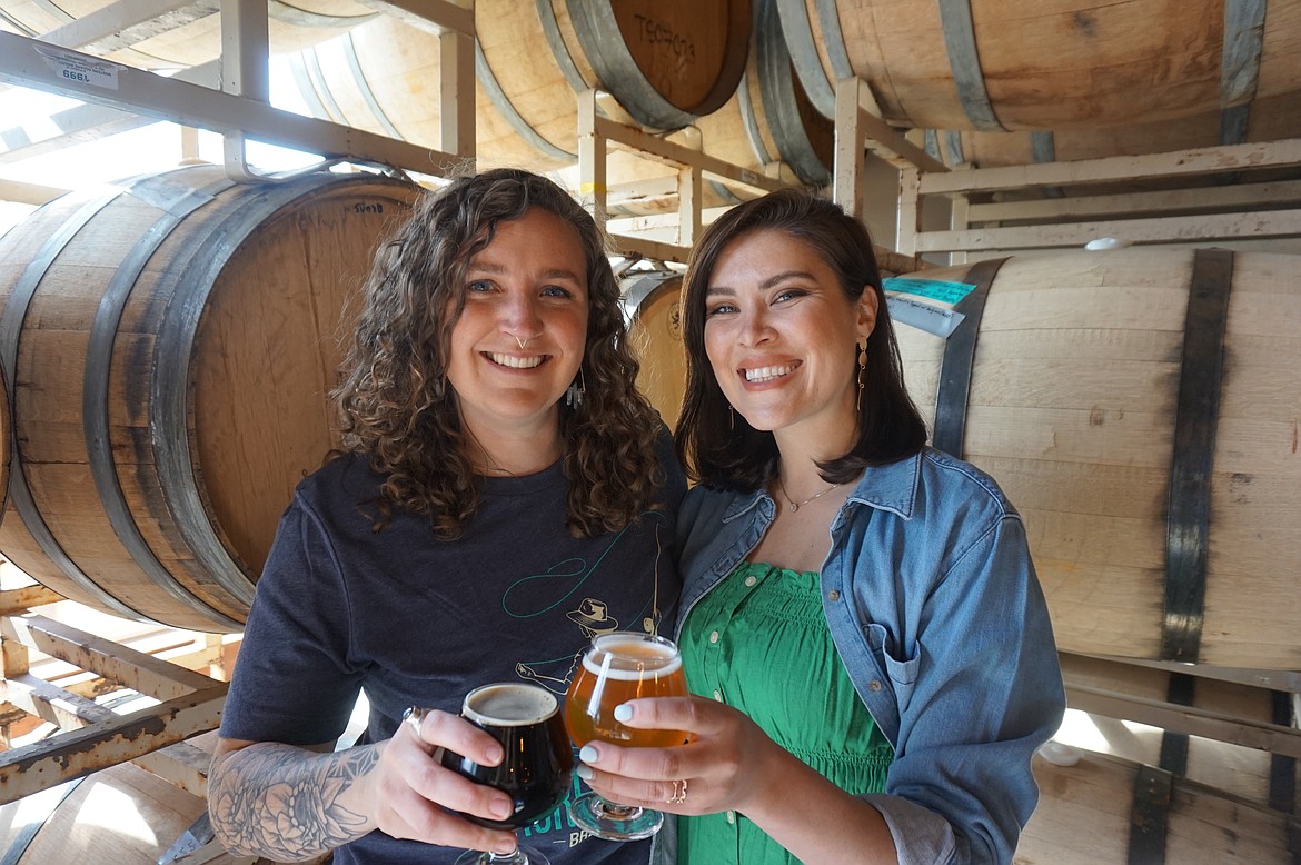 Jackie Evans, general manager, and Jordan Van Eimeren, founder of Sacred Waters Brewing Co., enjoy a beer at the brewery. (Summer Zalesky/Daily Inter Lake)