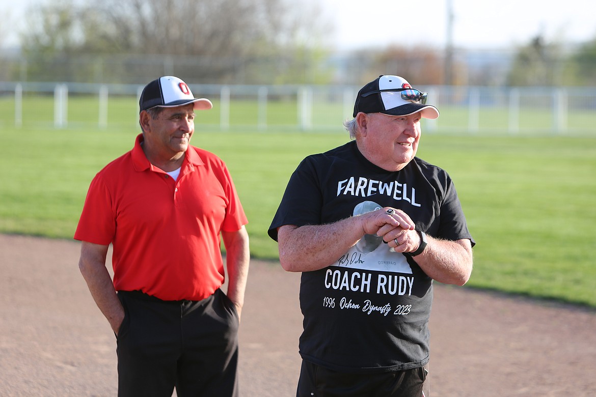 Othello assistant coach Mike Jensen, right, smiles next to Head Coach Rudy Ochoa, left, while wearing a shirt honoring the head coach’s final regular season home game.